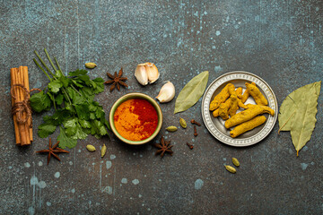Various Indian spices and herbs arranged on a rustic background .