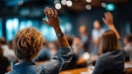 Defocused active participation at conference with attendees raising hands, blurred seminar scene asking questions or voting, with copy space