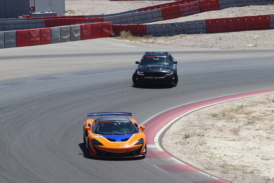 Mclaren and dodge hellcat sports cars on the racetrack