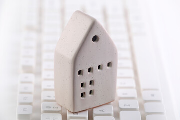 Small house on white computer keyboard
