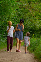 Mother with kids. Young child walks confidently outside, Innocent toddler strides with curiosity in nature, Young child ventures along woodland trail with independence and enthusiasm
