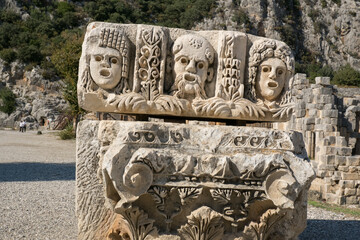 Ancient Stone Relief with Carved Faces of Mythological Figures in Demre, Turkey, Showcasing Lycian Artistry