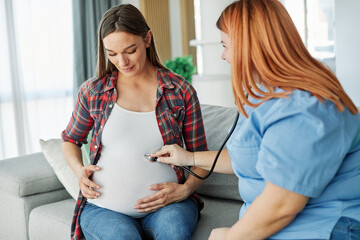 Portrait of a young happy pregnant woman doing exam with doctor or nurse during a visit at home or in a clinic, consultation appointment and  giving support, nurse using stethoscope