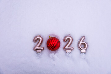 Stylish New Year 2026 winter scene with a ribbed red Christmas ornament replacing zero on snowy surface