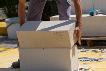 The bricklayer is working. Building a wall of aerated concrete. Gasbeton wall