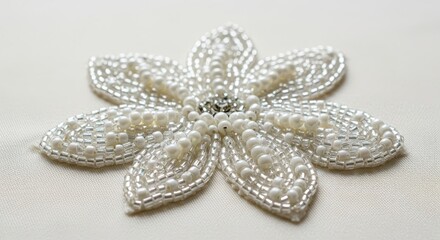 Detailed macro photograph showing sparkling white beads sewn onto soft ivory material creating a delicate abstract or floral pattern for luxury design, cream, lace, abstract