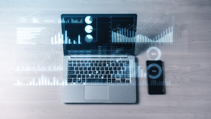 A modern workspace featuring a laptop and smartphone on a wooden desk, showcasing data analytics visualizations and graphs for business insights and productivity. Scalp