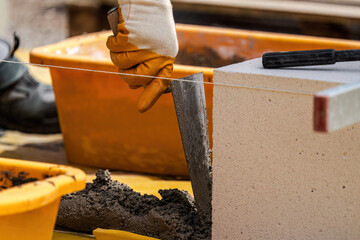 The bricklayer is working. Building a wall of aerated concrete. Gasbeton wall