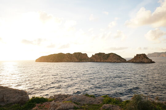 Scenic view of the rock formations Malgrat islands in the mediterranean sea during natural daylight on the coast of Mallorca, Santa Ponsa Region. The sunlight creates a warm ambiance, highlighting the