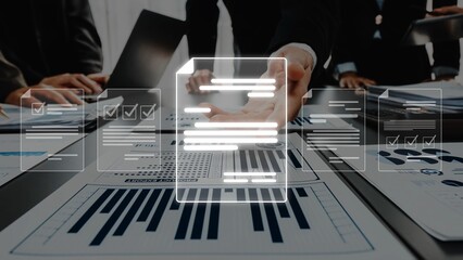 A collaborative team meeting focused on analyzing business documents and charts in an office environment, showcasing teamwork and strategic planning efforts. Raster