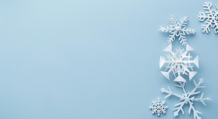 A serene winter scene with delicate white snowflakes arranged against a pastel blue background