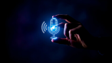 A person holding a glowing microphone in their hand against a dark background
