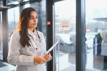 Female doctor standing with clipboard and stethoscope