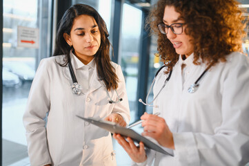 Female doctors discussing medical chart together in clinic