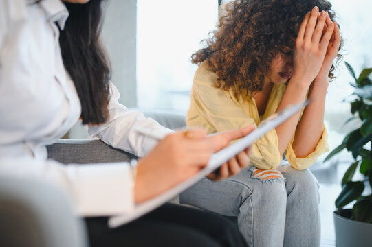 Indian psychologist counseling depressed female patient during therapy session