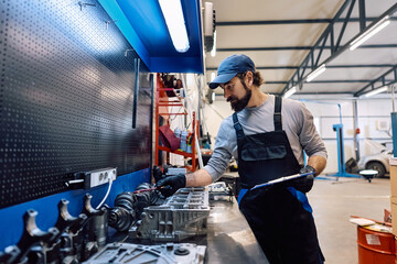 Mature mechanic taking inventory in auto repair shop.