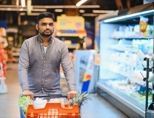 Man shopping for groceries in supermarket aisle