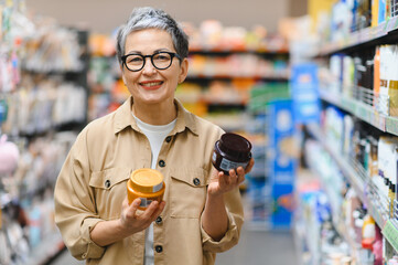 Senior woman choosing skincare products in retail store