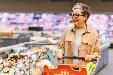 Senior woman smiling while grocery shopping in supermarket