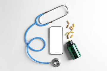 Telehealth. Smartphone, stethoscope and pills on light background, flat lay