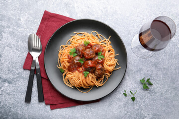 Delicious pasta with meatballs served on grey table, flat lay