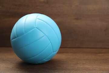 One volleyball ball on wooden table, space for text