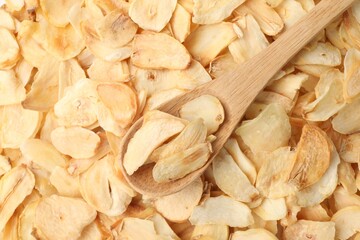 Dried garlic flakes and wooden spoon, top view
