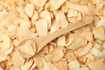 Dried garlic flakes and wooden spoon, top view