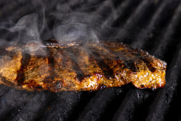 Chicken on grill with smoke