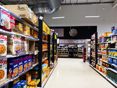 Busy grocery aisle in a UK supermarket featuring cereals and boxed goods in Manchester store