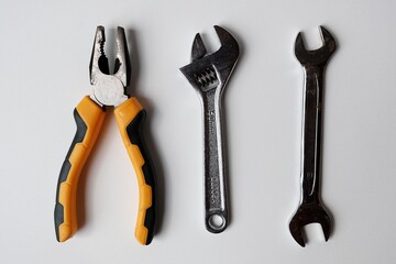 wrench, pliers and spanner on white background