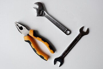 wrench, pliers and spanner on white background
