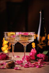 A stylish coupe glass with champagne and delicate rose petals, set against a warm and intimate background.