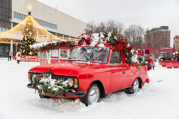Moscow, Russia, 12 January 2026,  Red vintage pickup truck decorated with Christmas wreaths and ornaments parked in a snowy square in Moscow, Russia.