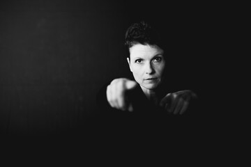 Determined businesswoman reaching forward against dark background