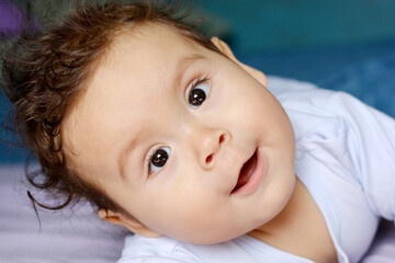Surprised latin baby with slightly opened mouth.