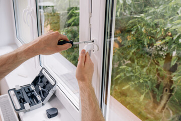 Repairman installing double glazed PVC window frame in a residential space