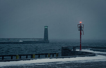 Cold winter weather in Europe. Lighthouse and pier in Gdynia	