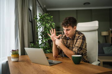Young man communicating using sign language on video call