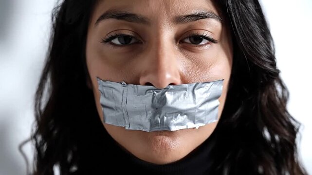 Woman silenced by duct tape symbolizing censorship or oppression