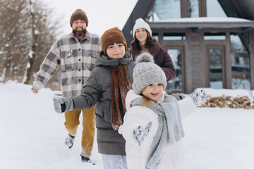 Obraz premium Happy family playing together enjoying winter vacation