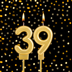 Number 39 birthday candle on a black background with blurred lights