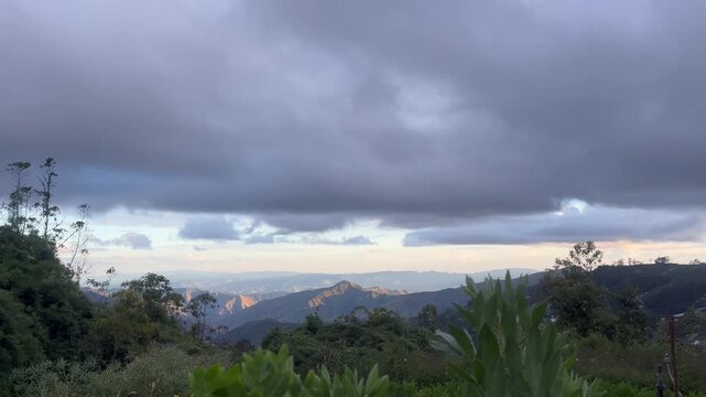 Dramatic mountain landscape under cloudy sky at sunset or sunrise