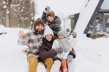 Young family enjoying winter vacation in snowy nature