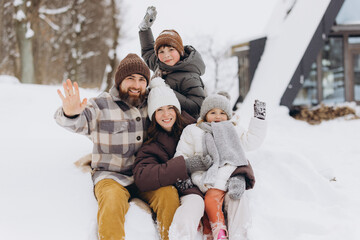 Family enjoying winter vacation waving outdoor in snow