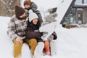 Happy family enjoying winter vacation in snowy landscape