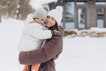 Mother and daughter embracing winter love and joy