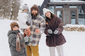 Family celebrating with sparklers in winter snow