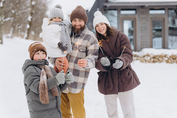 Family enjoying winter holiday celebration with sparklers