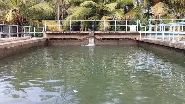 View of raw water flowing into a slow sand filter concrete basin at an outdoor municipal water treatment plant facility.